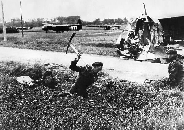 Airborne British commando troops who arrived in support of the glider troops dig in after