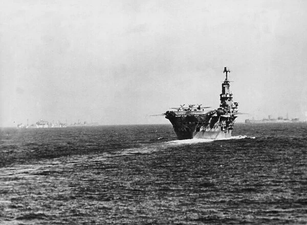 The aircraft carrier HMS Ark Royal supply convoy in the background making its way to