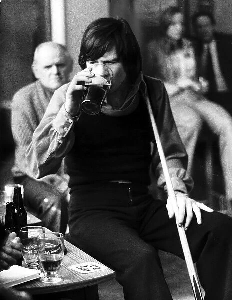 Alex Higgins snooker player drinking a pint of beer April 1973