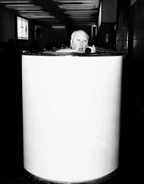 Framed Print : Alfred Hitchcock film director in a telephone booth in Heathrow Airport brochure