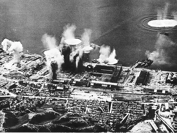 Allied bombs explode on dockside at Fuge Honshu Japan during a WW2 air raid - 1945
