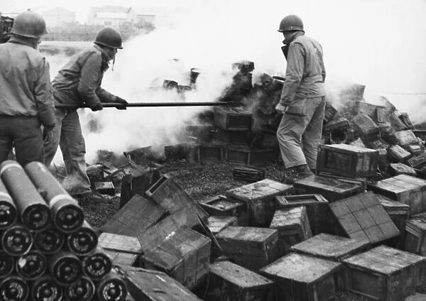 Allied troops fighting to extinguish a fire at an ammunition dump after a German air