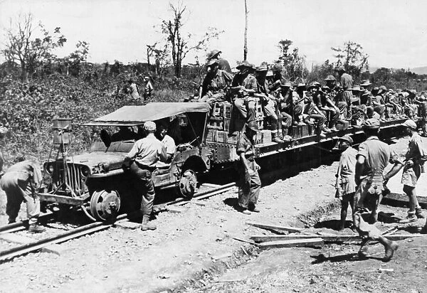 Allied troops use a jeep as a locomotive on the 37 mile railroad which runs from Mougang