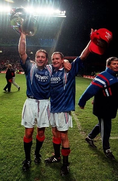 Ally McCoist waving trophy in the air with left arm around Paul Gascoignes neck