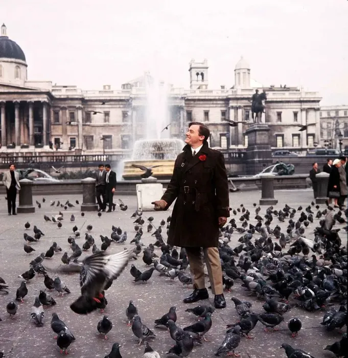 Framed Print : American actor Robert Vaughn feeds the pigeons in Trafalgar Square