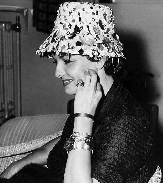 American actress Jane Russell wearing flowerpot hat holding her hand to her face