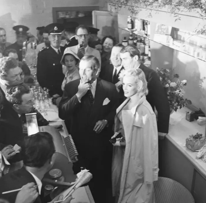Framed Print : American actress Marilyn Monroe and Sir Laurence Olivier seek refuge from the waiting