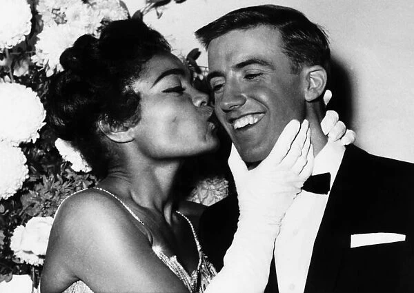 American actress and singer Eartha Kitt gives a kiss on the cheek to Roy Castle at