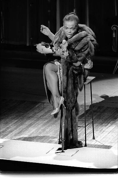American actress and singer Eartha Kitt warms up that sultriest of voices during a dress