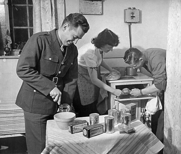 American army troops bring their own food rations to the kitchen of their hostess