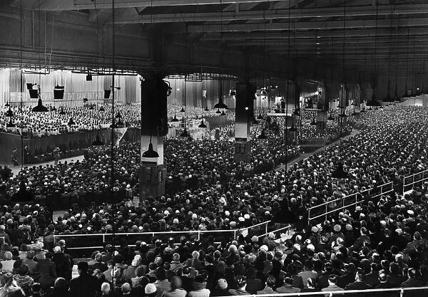 American evangelist Billy Graham addressing a huge crowd of people at Kelvin Hall in