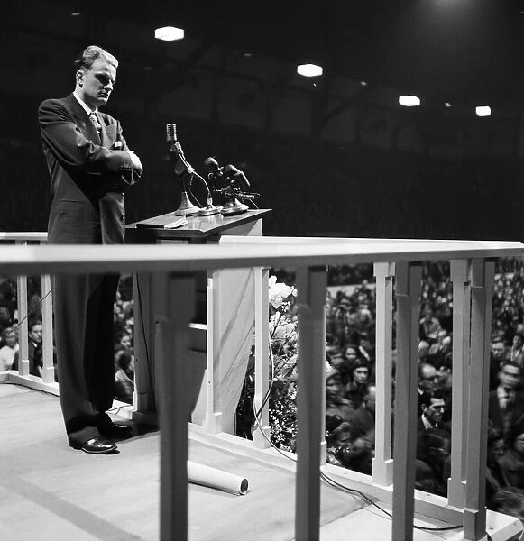 American evangelist Billy Graham speaks to the crowd at the Harringay Arena in North