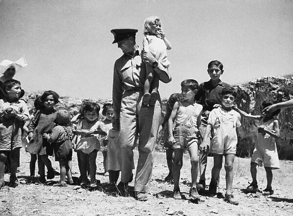 American officer with Sicilian children during Second World War. 17th August 1943