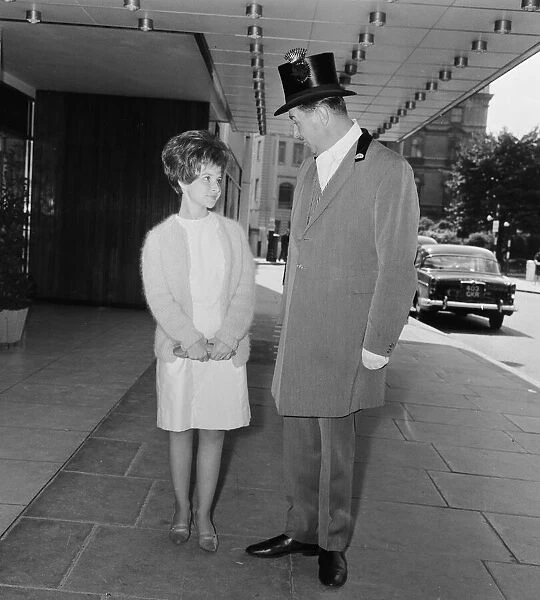 American pop singer Brenda Lee talking to one of the porters outside the Hilton Hotel in