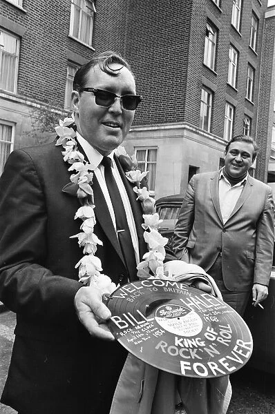 American rock and roll singer Bill Haley holds a record with a Welcome Back to Britain
