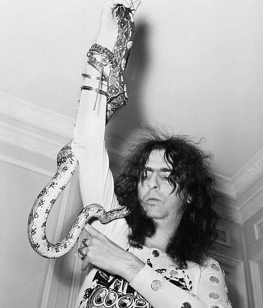 American rock singer Alice Cooper poses with his snake in London on his Love It To Death