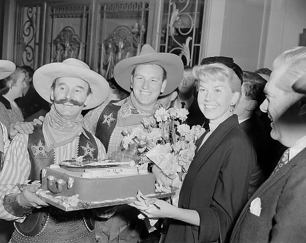 American singer and actress Doris Day pictured with men dressed in cowboy outfits