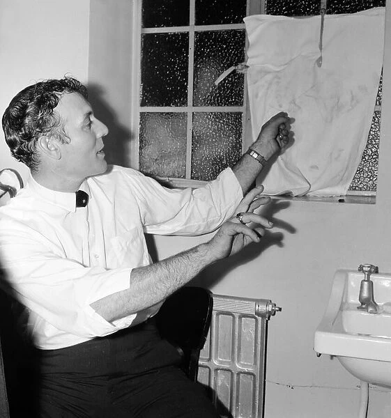 American singer Carl Perkins points to a smashed window in his dressing room at the Odeon