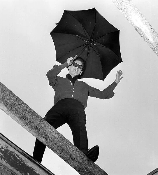 American singer Roy Orbison holding an umbrella at ATV House in London where he has