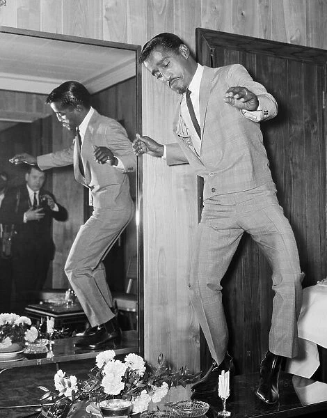 American singer Sammy Davis Junior performs a dance on a cocktail table at the Mayfair