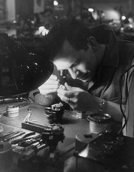 An American soldier of the Eighth Air Force mending part of a gyroscope for use on board
