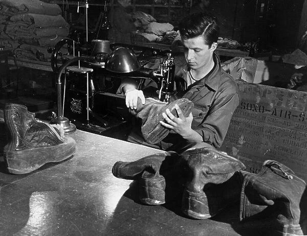 An American soldier mending a pair of boots for air men of the USaF Eighth Army at a