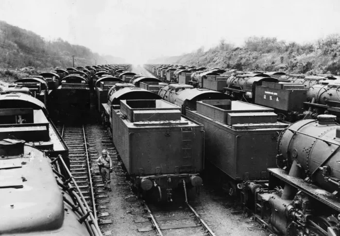 Framed Print : An American soldier stands on guard, surrounded American built locomotives at a rail