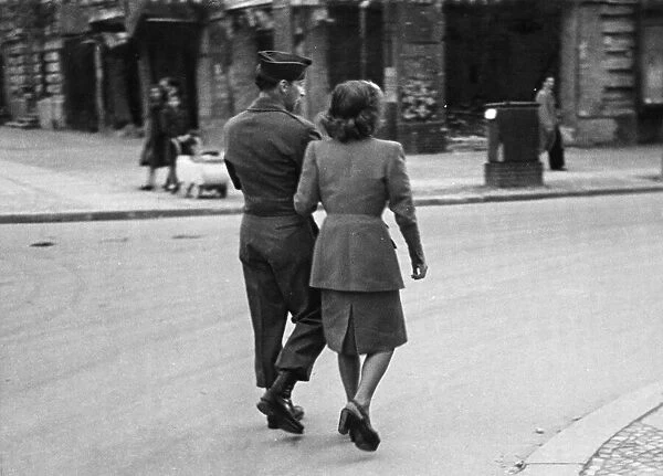 An American soldier walks arm in arm with a German civilian in Allied occupied Berlin at