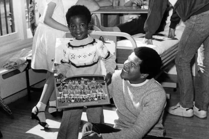 Framed Print : Andrew Hyman, aged 4, meets footballer Howard Gayle during a visit to the Children