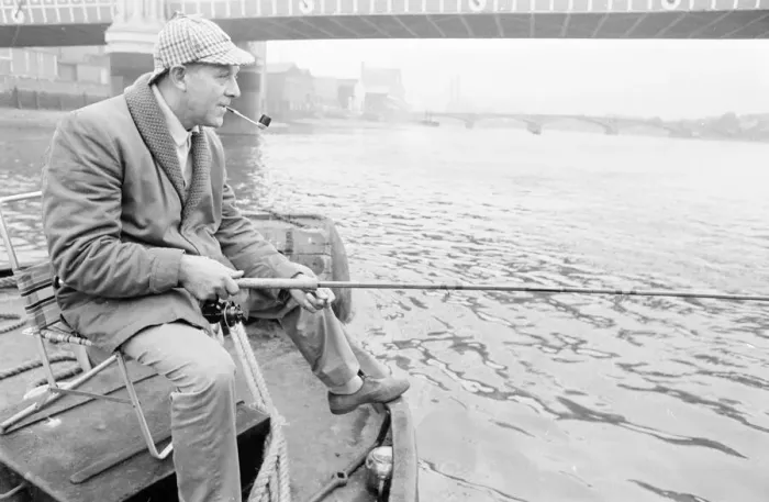 Framed Print : An angler from the Soho Firestation seen here fishing off a barge moored close to Framed Print : An angler from the Soho Firestation seen here fishing off a barge moored close to