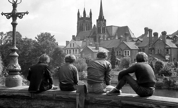 Angling. Young boys sitting on a bridge parapet fishing in the River Leam at Leamington