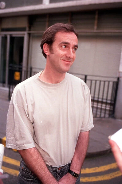 ANGUS DEAYTON WEARING T-SHIRT AND JEANS OUTSIDE SAVING HIS SOHO OFFICE IN LONDON
