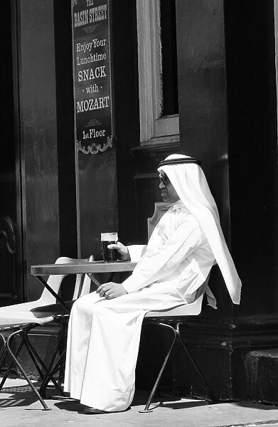 Arab man sitting outside enjoying a pint of Guinness at the Stanhope public house