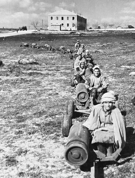 Arab workmen moving off to a bomb dump with fresh supplies during Second World War