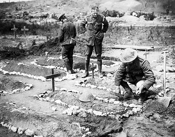 An army chaplain tending to a British soldiers grave in 1916 in France after the Battle