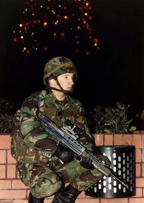 Framed Print : Army Soldier in camouflage uniform standing with a firearm in front of a Christmas tree Framed Print : Army Soldier in camouflage uniform standing with a firearm in front of a Christmas tree