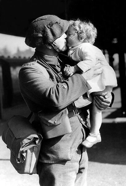 An army soldier kisses his child good bye - October 1939 as he leaves for war