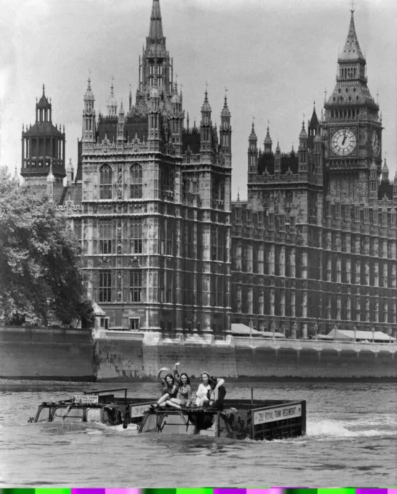 Framed Print : Army Vehicles. Amphibious. Two Army trucks transport three waving women through