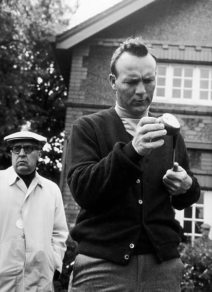 Arnold Palmer inspects one of his clubs. c. 1968