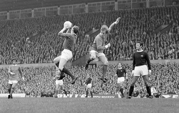 Arsenal goalkeeper Bob Wilson leaps up to claim a high ball from in front of Manchester
