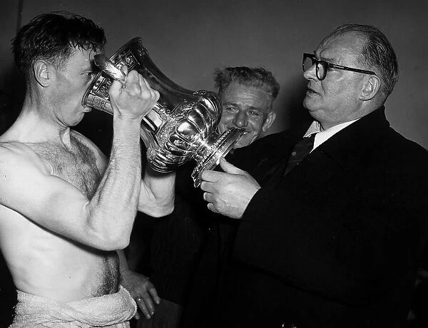 Arsenal skipper Joe Mercer celebrates his teams FA Cup win by drinking champagne