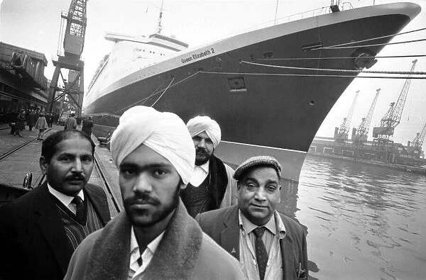 Asian immigrants arriving in Britain by ship, with the famous ocean liner QE2 behind