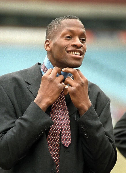 Aston Villa football player Ugo Ehiogu tying up his tie as he gets ready for the team