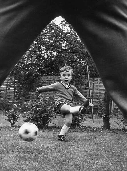Aston Villa footballer Ron Wylie playing football with his son Nigel in the garden of