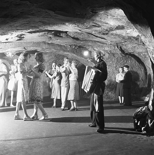 The audience of a performance of the Pirates of Penzance in the caves in the cliffs above