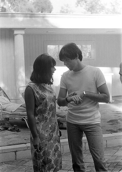 August 1964 Paul McCartney talking to girl at a pool in Private home in Bel Air Los