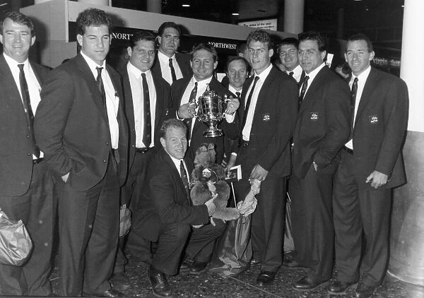 The Australian Rugby Union team pose with the Webb Ellis Cup at Gatwick Airport following