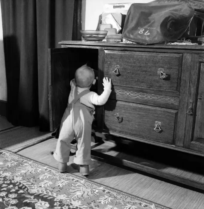 Framed Print : Baby boy looking in the cupboards at his home. October 1952 C5534-001 Framed Print : Baby boy looking in the cupboards at his home. October 1952 C5534-001