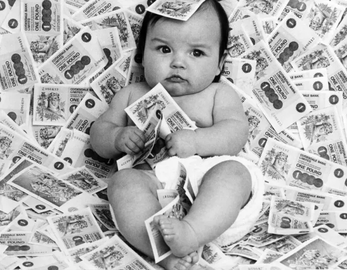 Framed Print : Baby Diane from Glasgow, Scotland, surrounded by bank notes from Clydesdale Bank Limited