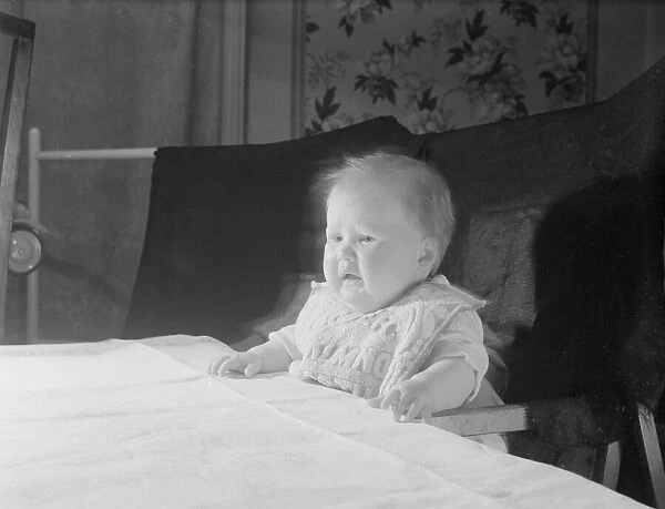 Baby in high chair at table crying. 22nd November 1952